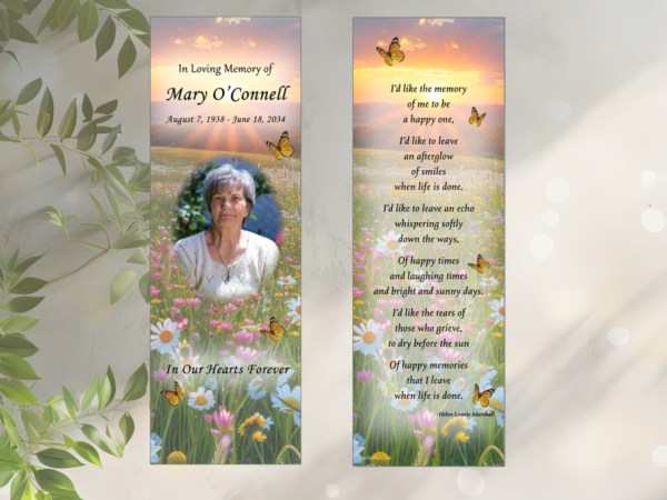 Wildflower background laminated memorial bookmark with photo of woman on front, In Loving Memory, followed by dates of birth and death, and In Our Hearts Forever. Back of bookmark also has wildflower background with sunset and poem: I’d like the memory of me to be a happy one, I’d like to leave an afterglow of smiles when life is done. I’d like to leave an echo whispering softly down the ways, Of happy times and laughing times and bright and sunny days. I’d like the tears of those who grieve, to dry before the sun Of happy memories that I leave when life is done. -Helen Lowrie Marshall